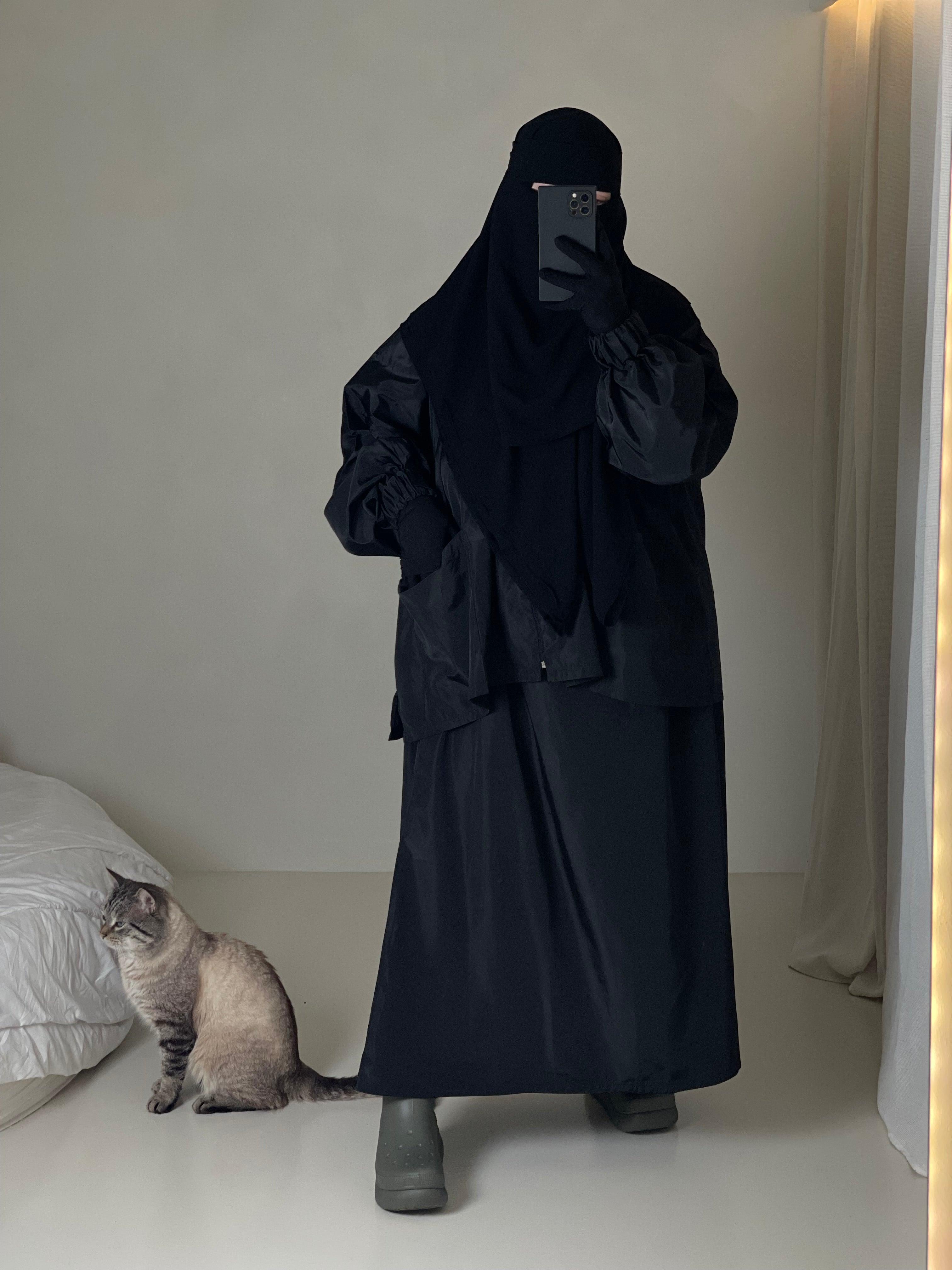 Femme musulmane portant une parka noire légiférée de la marque hijrati  