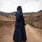Femme musulmane portant une parka noire légiférée de la marque hijrati  