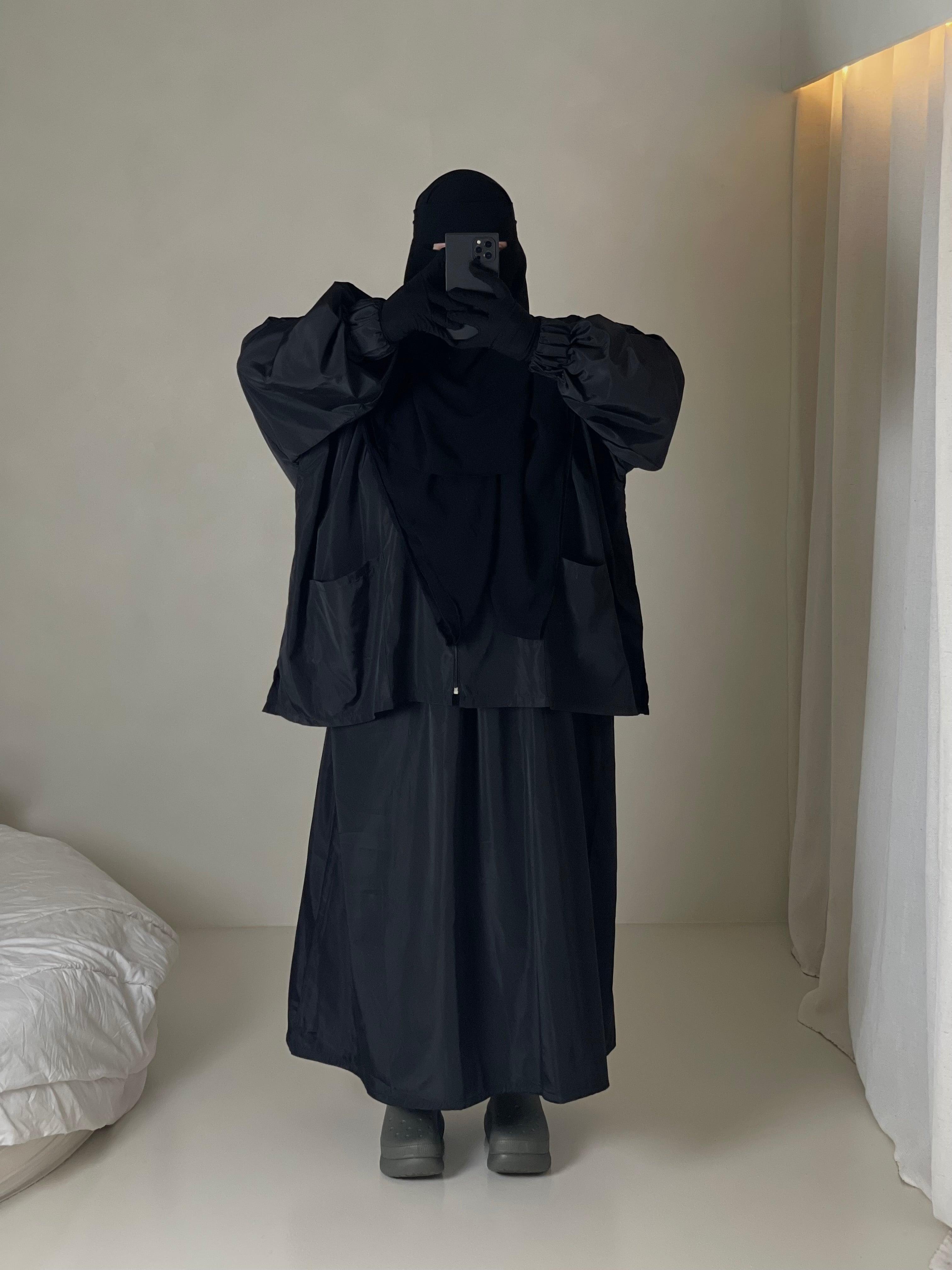 Femme musulmane portant une parka noire légiférée de la marque hijrati  