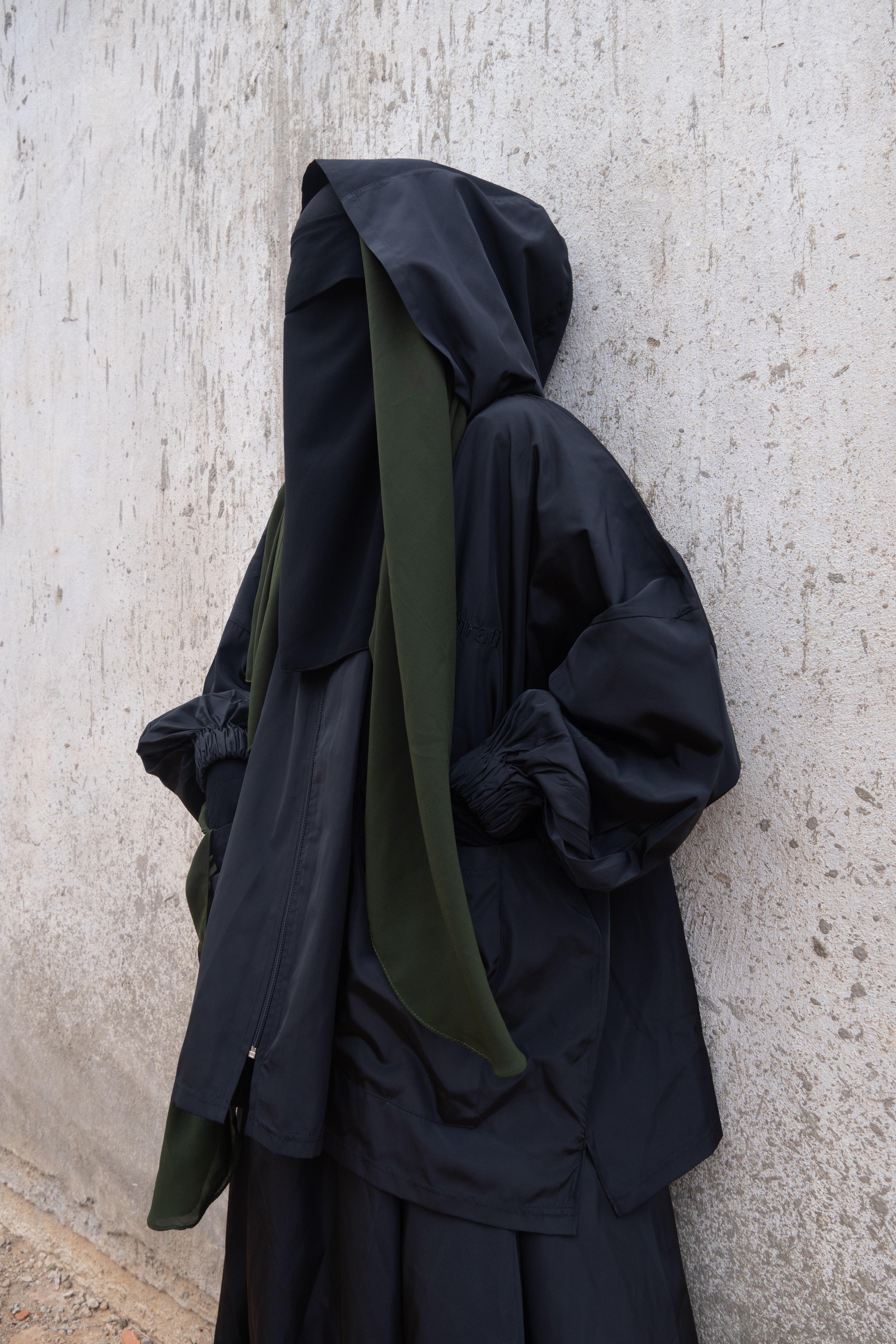 Femme musulmane portant une parka noire légiférée de la marque hijrati  