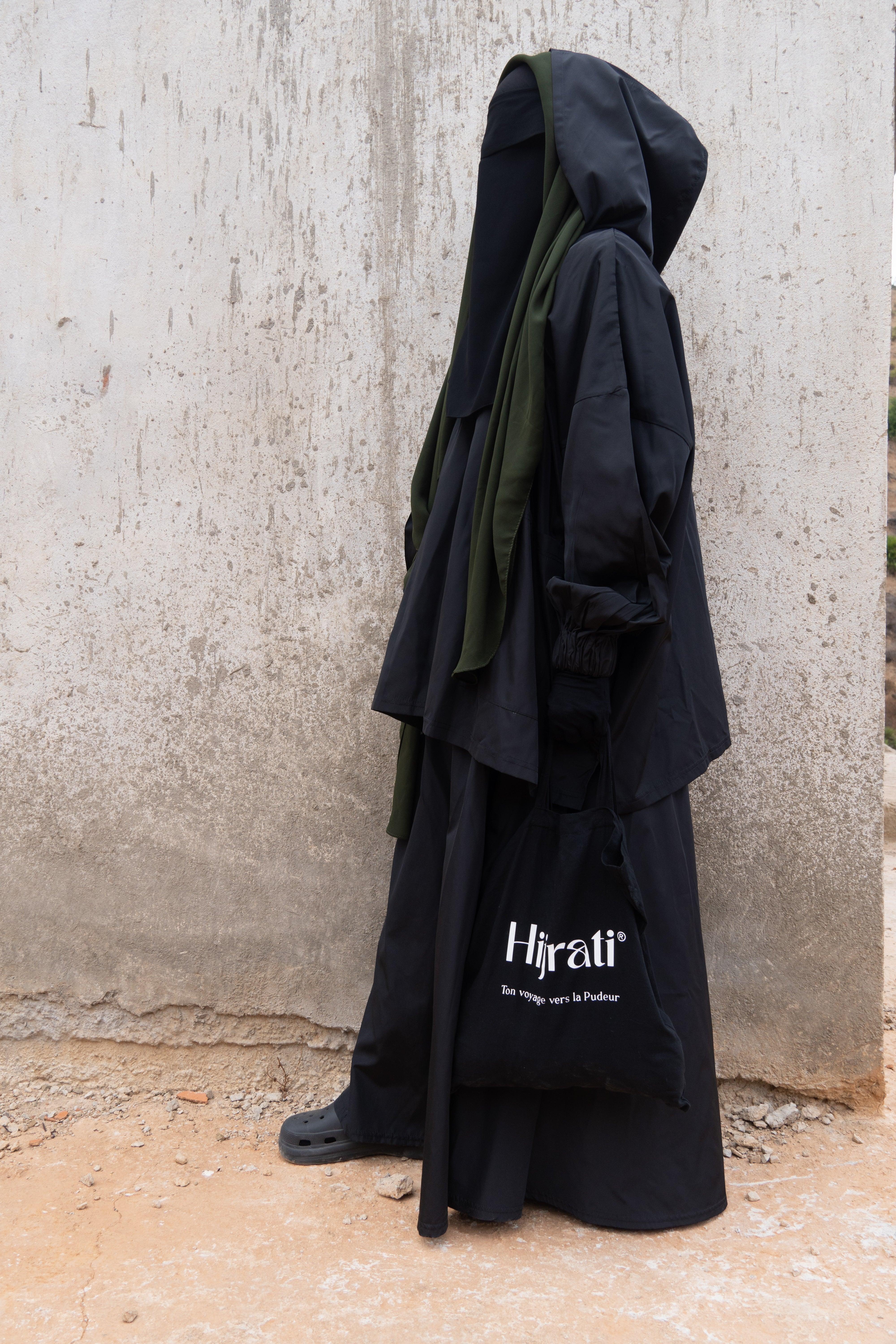 Femme musulmane portant une parka noire légiférée de la marque hijrati  